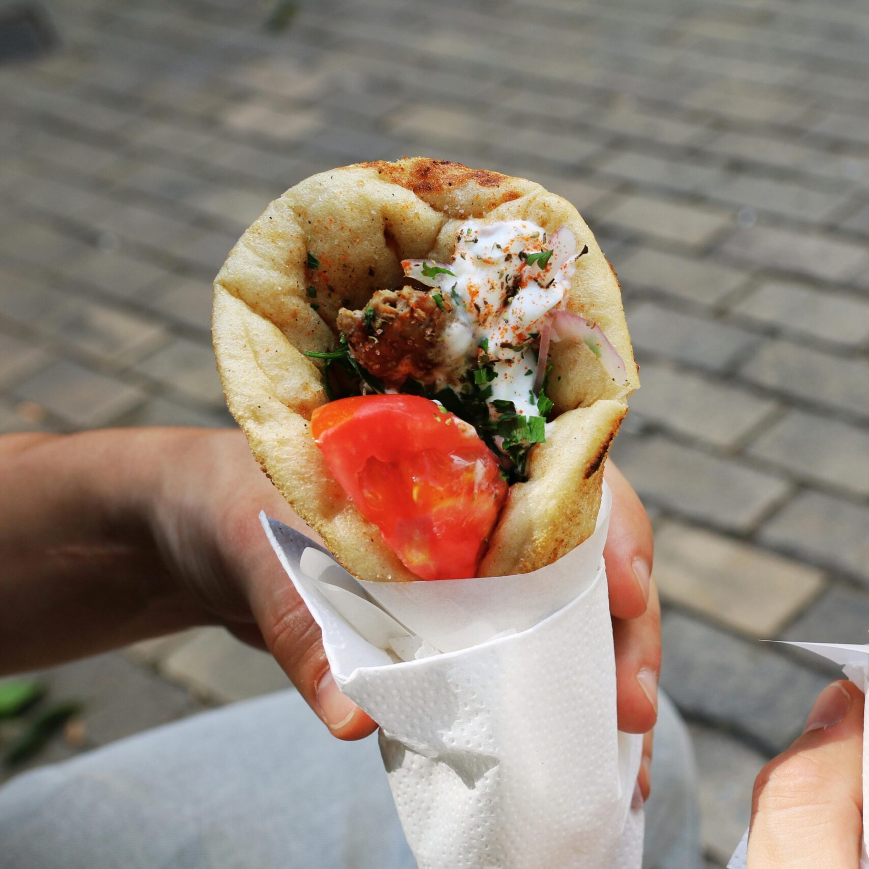 Two fresh gyros with tomato and herbs, perfect Greek street food for a sunny day.